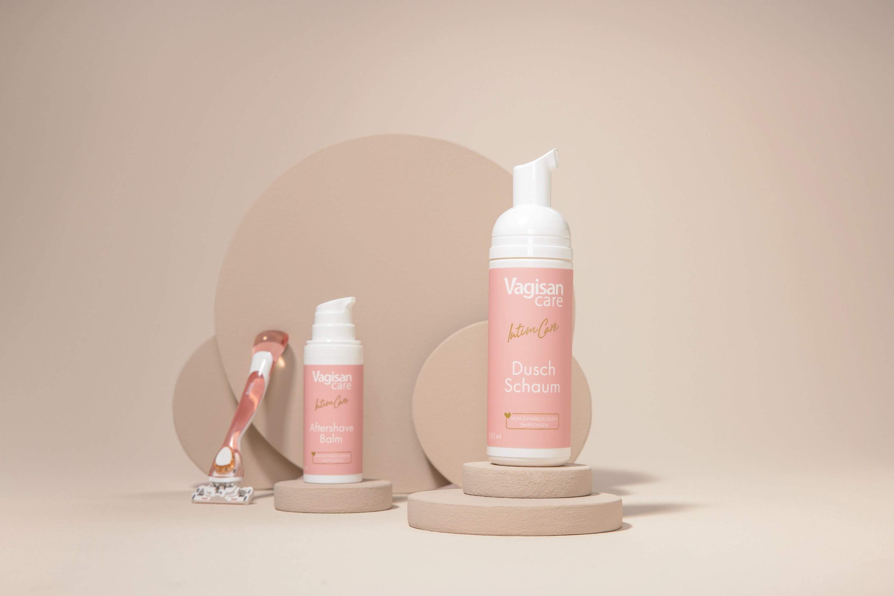 Produkt-Spender VagisanCare Dusch Schaum und VagisanCare Aftershave Balm neben einem Rasierer für die Bikinizione